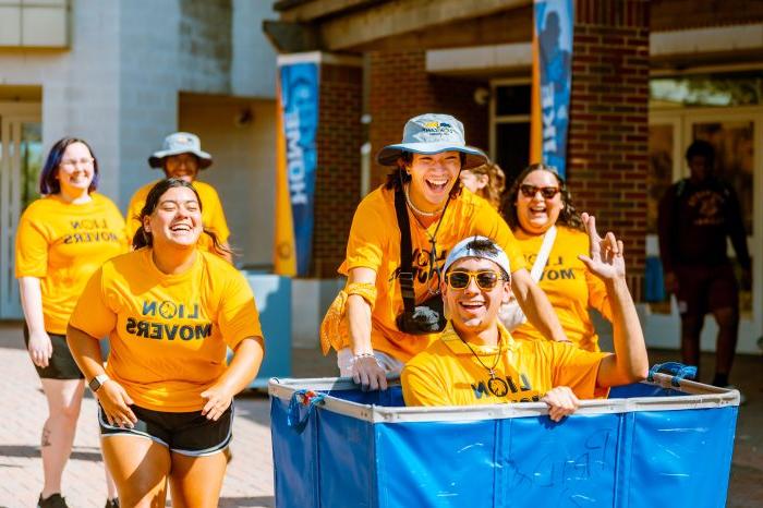 A group of students with Lion movers t-shirt walking some where.